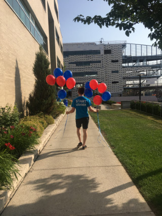 Rear view of Start Leader holding 12 balloons